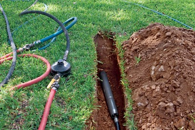 Pipe laid in a trench across a lawn during an underground installation